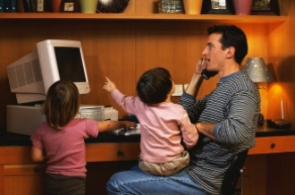 Learn anytime, from anywhere (man at home computer with child on lap).
